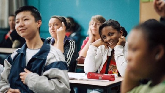 Adolescentes sonríen en una sala de clases.